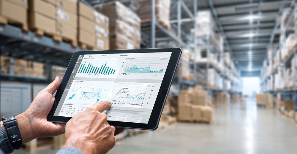 Retail manager reviewing inventory and performance data on a tablet inside a warehouse